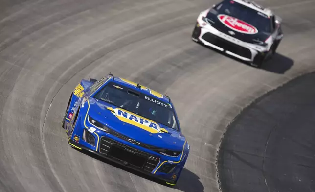 Chase Elliott (9) leads Christopher Bell (20) during a NASCAR Cup Series auto race at Dover Motor Speedway, Sunday, July 20, 2025, in Dover, Del. (AP Photo/Derik Hamilton)