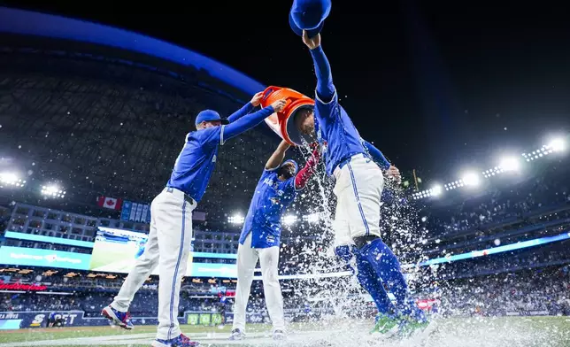 Toronto Blue Jays' George Springer, right, is doused by teammates after defeating the New York Yankees in baseball game action in Toronto, Thursday, July 3, 2025. (Thomas Skrlj/The Canadian Press via AP)