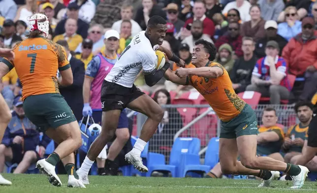 Fiji's Jiuta Wainiqolo, center, breaks through the Australian defense during their rugby union international match in Newcastle, Australia, Sunday, July 6, 2025. (AP Photo/Mark Baker)