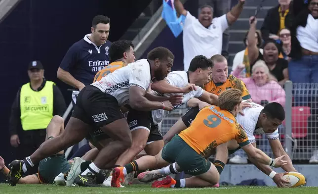Fiji's Salesi Rayasi, right, scores a try as Australia's Tate McDermott is unable to stop the score during their rugby union international match in Newcastle, Australia, Sunday, July 6, 2025. (AP Photo/Mark Baker)