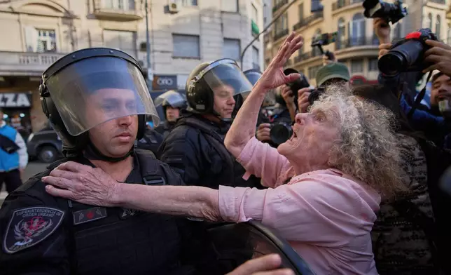 Delia Donn, 78, gestures to a riot policeman near Congress during weekly protests demanding better pensions for retirees, in Buenos Aires, Argentina, Wednesday, July 30, 2025. (AP Photo/Rodrigo Abd)