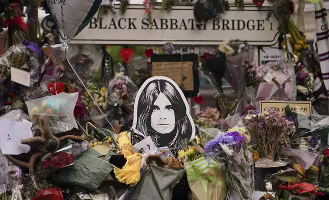 Floral tributes in front of the 'Black Sabath bridge' to honour musician Ozzy Osbourne as thousands of fans gathered to watch a funeral procession for Black Sabbath frontman Ozzy Osbourne following his death aged 76, in Birmingham, England, Wednesday, July 30, 2025. (AP Photo/Alberto Pezzali)
