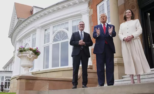 President Donald Trump, center, speaks with the media as he greets Britain's Prime Minister Keir Starmer, left, and his wife Victoria at the Trump Turnberry golf course in Turnberry, Scotland Monday, July 28, 2025. (AP Photo/Jacquelyn Martin)