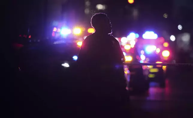 A New York Police officer stands at the scene on 52nd Street outside a Manhattan office building where two people were shot, including a New York police officer, Monday, July 28, 2025, in New York. (AP Photo/Angelina Katsanis)