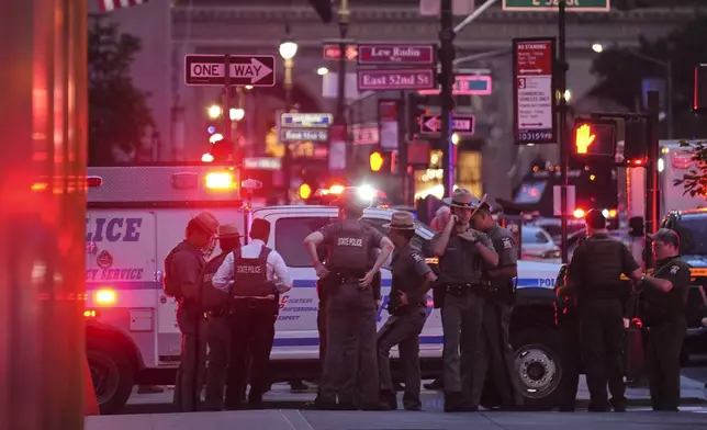 New York State Police troopers gather on 52nd Street outside a Manhattan office building where two people were shot, including a New York police officer, Monday, July 28, 2025, in New York. (AP Photo/Angelina Katsanis)
