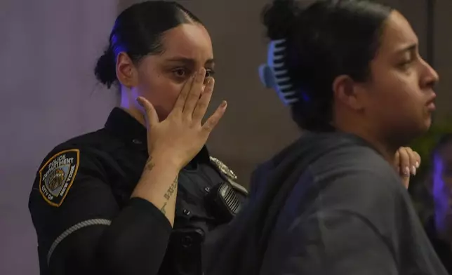 New York Police officers react as they gather outside New York Presbyterian Weil Cornell Medical Center where a police officer was brought after being shot at a Manhattan office building, Monday, July 28, 2025, in New York. (AP Photo/Angelina Katsanis)