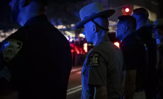 Officers line up during the dignified transfer of Didarul Islam, who was shot and killed by a gunman earlier this evening, out of NewYork-Presbyterian/Weill Cornell Medical Hospital to the medical examiner's office, early Tuesday, July 29, 2025, in New York. (AP Photo/Angelina Katsanis)