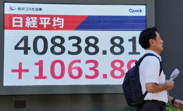 A person walks in front of an electronic stock board showing Japan's Nikkei index at a securities firm Wednesday, July 23, 2025, in Tokyo. (Kyodo News via AP)