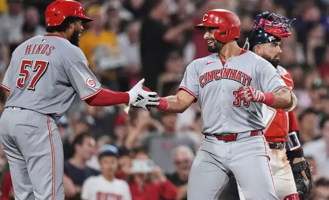 Cincinnati Reds' Christian Encarnacion-Strand, right, is congratulated by Rece Hinds (57) after his grand slam drive against the Boston Red Sox during the seventh inning of a baseball game at Fenway Park, Wednesday, July 2, 2025, in Boston. (AP Photo/Charles Krupa)