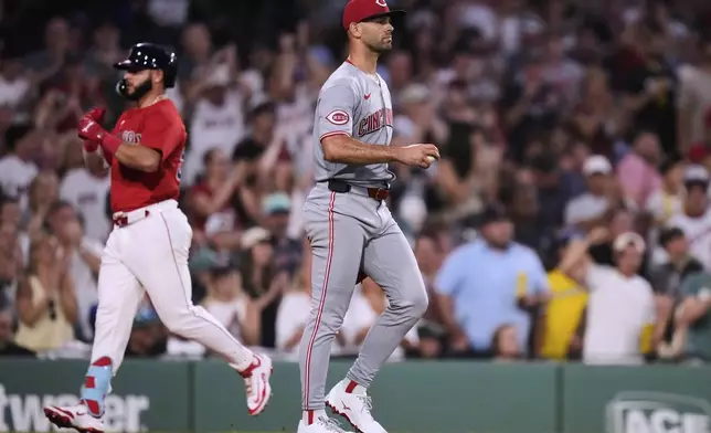 Cincinnati Reds pitcher Nick Martinez walks back to the mound with a fresh baseball as Boston Red Sox's Wilyer Abreu, left, rounds the bases on his two-run home run during the sixth inning of a baseball game at Fenway Park, Wednesday, July 2, 2025, in Boston. (AP Photo/Charles Krupa)