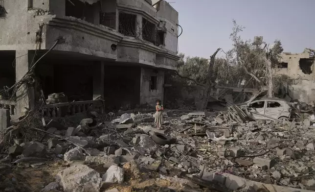 A Palestinian girl stands atop the rubble of the Al-Aimawi family's home that was destroyed by Israeli airstrikes in Al-Zawaideh, Gaza Strip, Tuesday, July 1, 2025. (AP Photo/Abdel Kareem Hana)