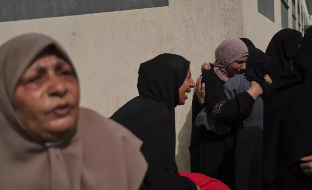 Mourners attend the funeral of members of Al-Aimawi family who were killed in an Israeli bombardment of Al-Zawaideh, outside the Al-Aqsa Hospital morgue in Deir al-Balah, Gaza Strip, on Tuesday, July 1, 2025. (AP Photo/Abdel Kareem Hana)