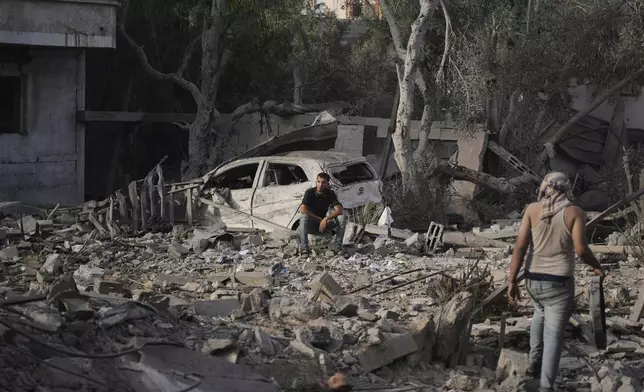 Palestinians inspect the rubble of the Al-Aimawi family's home, destroyed by Israeli airstrikes in Al-Zawaideh, Gaza Strip, on Tuesday, July 1, 2025. (AP Photo/Abdel Kareem Hana)
