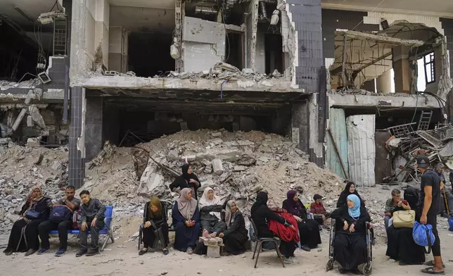 Kidney patients sit amid the destruction caused by the Israeli army at Shifa Hospital compound in Gaza City on Tuesday, July 1, 2025, as they wait to leave after the facility suspended its dialysis unit services due to fuel shortages needed to power its generators. (AP Photo/Jehad Alshrafi)