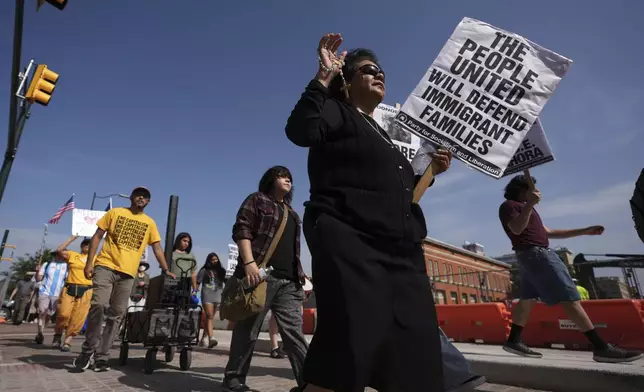 Sister RoseAnn Castilleja, center, holds a Rosary and sign as she marches with other immigration advocates as they protest recent detentions by ICE outside the immigration court in San Antonio, Texas, Tuesday, July 1, 2025. (AP Photo/Eric Gay)