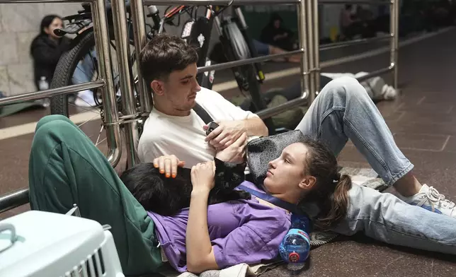 People rest in a metro station, being used as a bomb shelter, during a Russian attack in Kyiv, Ukraine, early Thursday, July 10, 2025. (AP Photo/Efrem Lukatsky)
