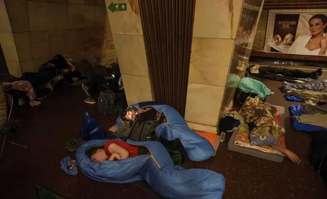 People sleep on the platform of a metro station as they take cover during a Russian attack on Kyiv, Ukraine, on Thursday, July 10, 2025. (AP Photo/Evgeniy Maloletka)