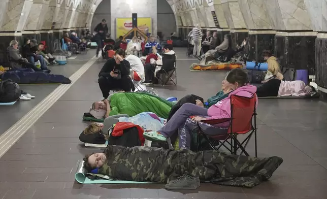 People rest in a metro station, being used as a bomb shelter, during a Russian attack in Kyiv, Ukraine, early Thursday, July 10, 2025. (AP Photo/Efrem Lukatsky)