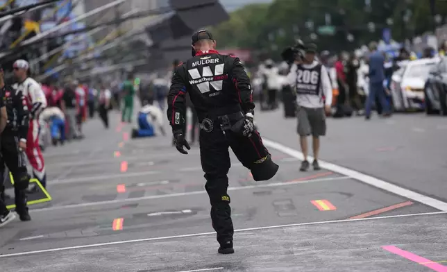A pit crew member stretches before a NASCAR Cup Series auto race at the Grant Park 165 , Sunday, July 6, 2025, in Chicago. (AP Photo/Erin Hooley)