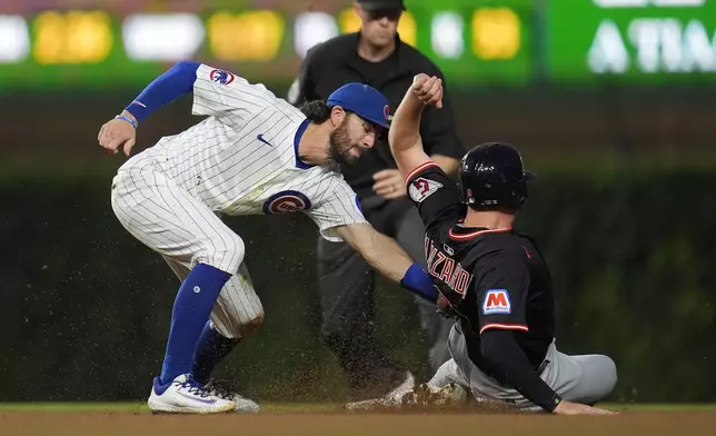 Cleveland Guardians designated hitter Kyle Manzardo, right, is caught stealing second by Chicago Cubs shortstop Dansby Swanson, left, during the sixth inning of a baseball game Thursday, July 3, 2025, in Chicago. (AP Photo/Erin Hooley)