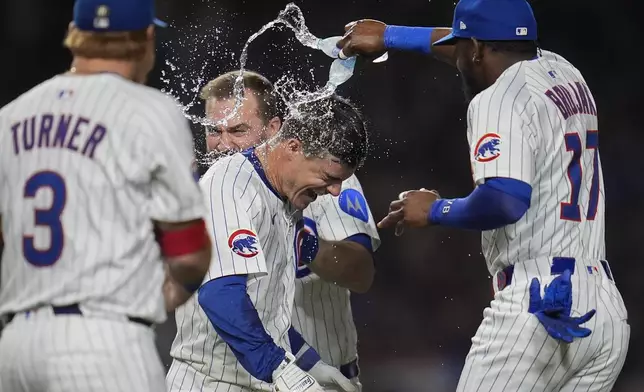 Chicago Cubs' Matt Shaw, center front, is doused after hitting a walkoff home run in the 10th inning to win a baseball game against the Cleveland Guardians, Thursday, July 3, 2025, in Chicago. (AP Photo/Erin Hooley)