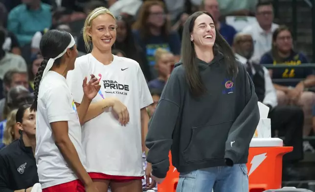 Indiana Fever players, from left, Sydney Colson, Sophie Cunningham and Caitlin Clark react on the bench during the first half of a WNBA basketball game against the Dallas Wings Friday, June 27, 2025, in Dallas. (AP Photo/Julio Cortez)