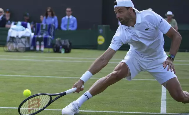 Grigor Dimitrov of Bulgaria returns to Corentin Moutet of France during their second round men's singles match at the Wimbledon Tennis Championships in London, Thursday, July 3, 2025. (AP Photo/Joanna Chan)