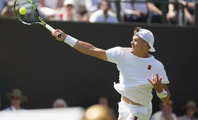 Holger Rune of Denmark returns to Nicolas Jarry of Chile in their first round men's singles match at the Wimbledon Tennis Championships in London, Monday, June 30, 2025. (AP Photo/Joanna Chan)