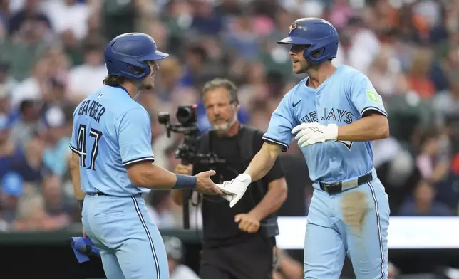 Toronto Blue Jays' Ernie Clement, right, celebrates his three-run home run with Addison Barger (47) against the Detroit Tigers during the sixth inning of a baseball game Thursday, July 24, 2025, in Detroit. (AP Photo/Paul Sancya)
