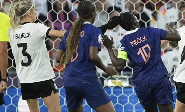 Germany's Kathrin Hendrich, left, pulls on hair of France's Griedge Mbock Bathy, right, during the Women's Euro 2025 quarterfinals soccer match between France and Germany at St. Jakob-Park in Basel, Switzerland, Saturday, July 19, 2025. (AP Photo/Martin Meissner)