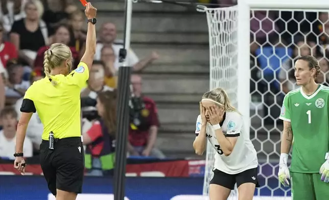 Germany's Kathrin Hendrich, center, receives a red card during the Women's Euro 2025 quarterfinals soccer match between France and Germany at St. Jakob-Park in Basel, Switzerland, Saturday, July 19, 2025. (AP Photo/Martin Meissner)
