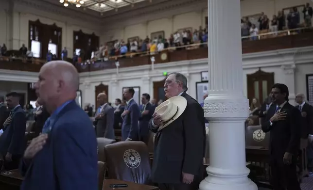 Texas State Rep. Cecil Bell, Jr., R-Magnolia, center and other house member stand for the pledge as the House calls a Special Session, Monday, July 21, 2025, in Austin. (AP Photo/Eric Gay)