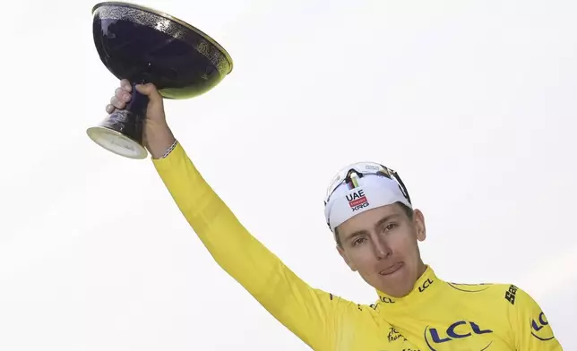 Tour de France winner Tadej Pogacar of Slovenia holds the trophy after the twenty-first stage of the Tour de France cycling race over 132.3 kilometers (82.1 miles) with start in Mantes-la-Ville and finish on the Champs-Elysees in Paris, France, Sunday, July 27, 2025. (AP Photo/Thibault Camus)
