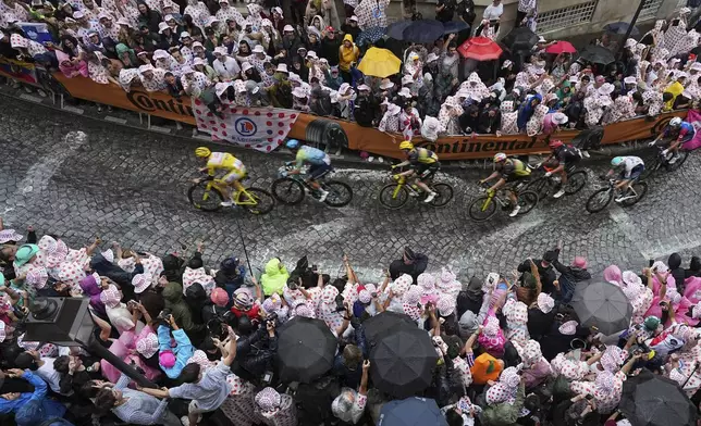 Slovenia's Tadej Pogacar , wearing the overall leader's yellow jersey, leads the pack as they pedal up the Montmartre hill during the last stage of the Tour de France cycling race between Mantes-la-Ville and Paris, Sunday, July 27, 2025 in Paris (AP Photo/Laurent Cipriani)