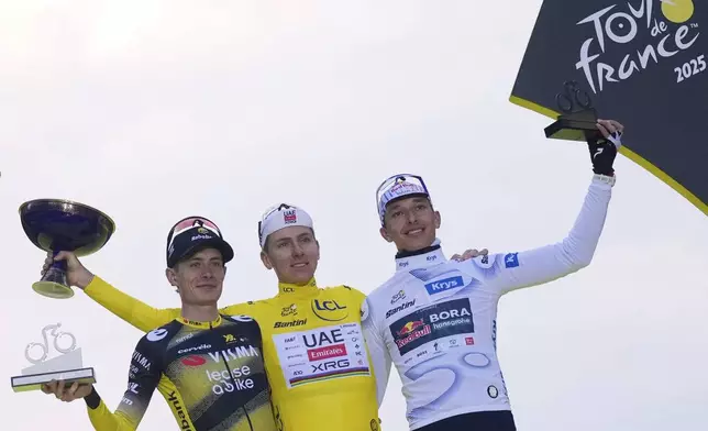 Tour de France winner Tadej Pogacar of Slovenia, center, Denmark's Jonas Vingegaard, who took second place, and Germany's Florian Lipowitz, wearing the best young rider's white jersey, right, who took third place, celebrate on the podium after the twenty-first stage of the Tour de France cycling race over 132.3 kilometers (82.1 miles) with start in Mantes-la-Ville and finish on the Champs-Elysees in Paris, France, Sunday, July 27, 2025. (AP Photo/Mosa'ab Elshamy)