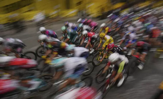 The pack with Slovenia's Tadej Pogacar, wearing the overall leader's yellow jersey, rides during the twenty-first stage of the Tour de France cycling race over 132.3 kilometers (82.1 miles) with start in Mantes-la-Ville and finish on the Champs-Elysees in Paris, France, Sunday, July 27, 2025. (AP Photo/Thibault Camus)