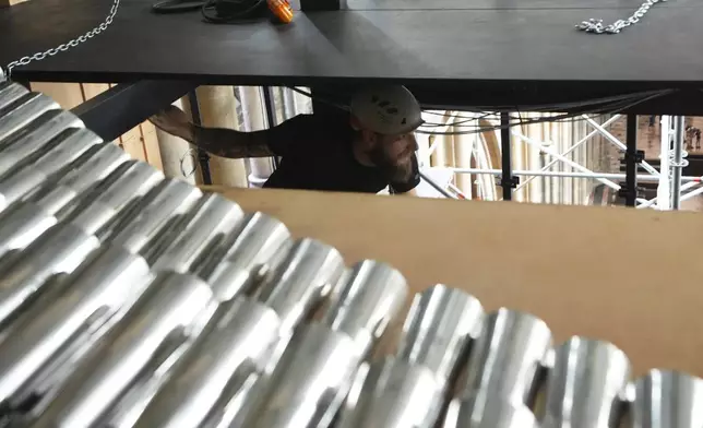A worker walks on scaffolding during the installation of a new organ at Prague's St. Vitus Cathedral that is coming to its final stages in Prague, Czech Republic, Tuesday, July 22, 2025. (AP Photo/Petr David Josek)
