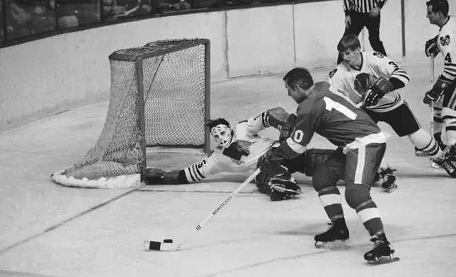 FILE - Chicago Blackhawk goalie Tony Esposito stretches to block Detroit Red Wing Captain Alex Delvecchio shot as Keith Magnuson moves in on defense, during the third period of a Stanley Cup hockey playoff game in Detroit, April 13, 1970. (AP Photo, File)