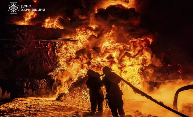 In this photo provided by the Ukrainian Emergency Service, emergency services personnel work to extinguish a fire following a Russian attack in Kharkiv region, Ukraine, Saturday, July 5, 2025. (Ukrainian Emergency Service via AP)
