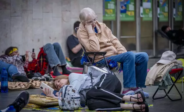 People hide in a metro station, being used as a bomb shelter, during a Russian drones attack in Kyiv, Ukraine, early hours Saturday, July 5, 2025. (AP Photo/Dan Bashakov)