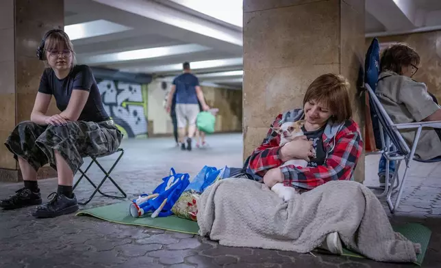People hide in a metro station, being used as a bomb shelter, during a Russian drones attack in Kyiv, Ukraine, early hours Saturday, July 5, 2025. (AP Photo/Dan Bashakov)