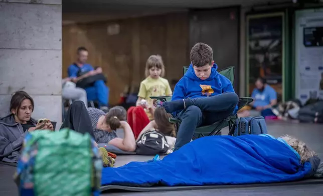 People hide in a metro station, being used as a bomb shelter, during a Russian drones attack in Kyiv, Ukraine, early hours Saturday, July 5, 2025. (AP Photo/Dan Bashakov)