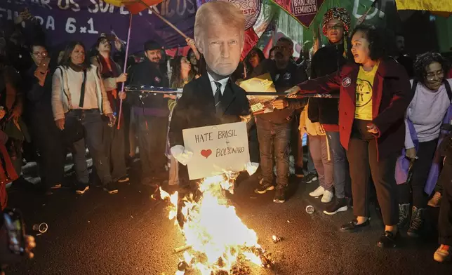 Protesters set fire to an effigy of U.S. President Donald Trump in response to his announcement of 50% tariffs on Brazilian goods, in Sao Paulo, Thursday, July 10, 2025. (AP Photo/Andre Penner)