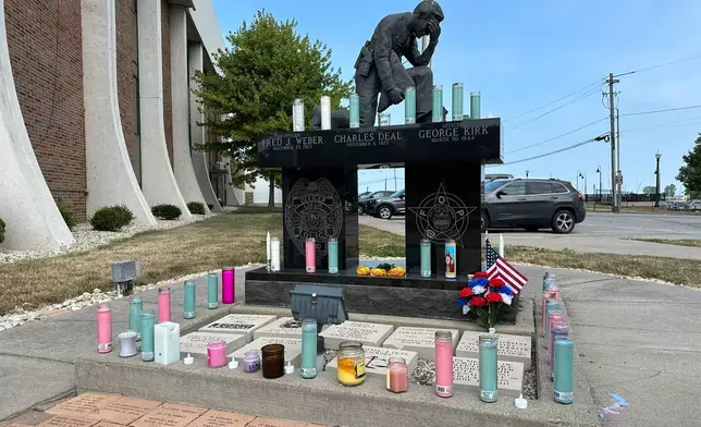 Candles sit on a memorial outside the police department in Lorain, Ohio, on Thursday, July 24, 2025, a day after three officers were wounded in a shooting ambush. (AP Photo/John Seewer)
