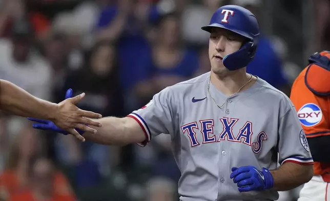 Texas Rangers' Wyatt Langford is congratulated after hitting a two-run home run during the seventh inning of a baseball game against the Houston Astros, Friday, July 11, 2025, in Houston. (AP Photo/Kevin M. Cox)