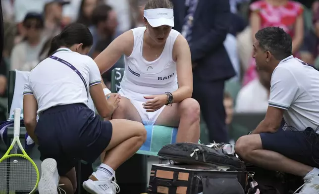 Barbora Krejcikova of Czech Republic gets assistance during her women's singles third round match against Emma Navarro of the U.S. at the Wimbledon Tennis Championships in London, Saturday, July 5, 2025.(AP Photo/Alastair Grant)
