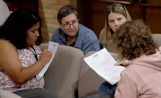 In this image taken from video, participants filling out a questionnaire during a training hosted by Undivided at Central Christian Church in Springfield, Ohio, aimed at teaching community and church leaders how to support and shelter immigrants facing deportation, Tuesday, July 29, 2025. (AP Photo/Obed Lamy)