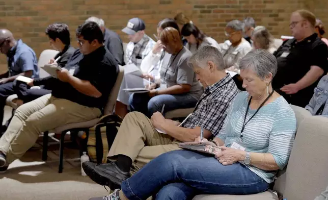 In this image taken from video, participants take notes during a training hosted by Undivided at Central Christian Church in Springfield, Ohio, aimed at teaching community and church leaders how to support and shelter immigrants facing deportation, Tuesday, July 29, 2025. (AP Photo/Obed Lamy)