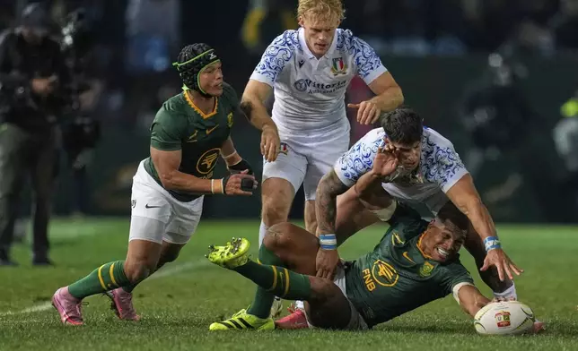 South Africa's Damian Willemse, bottom right, vies for the ball with Italy's Tommaso Menoncello, top right, during a rugby championship test match between South Africa and Italy, at Loftus Versfeld stadium in Pretoria, South Africa, Saturday, July 5, 2025. (AP Photo/Themba Hadebe)