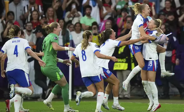 England players celebrate after England's Chloe Kelly, right, scored the decisive penalty in a penalty shootout at the end of the Women's Euro 2025 final soccer match between England and Spain at St. Jakob-Park in Basel, Switzerland, Sunday, July 27, 2025. (AP Photo/Alessandra Tarantino)